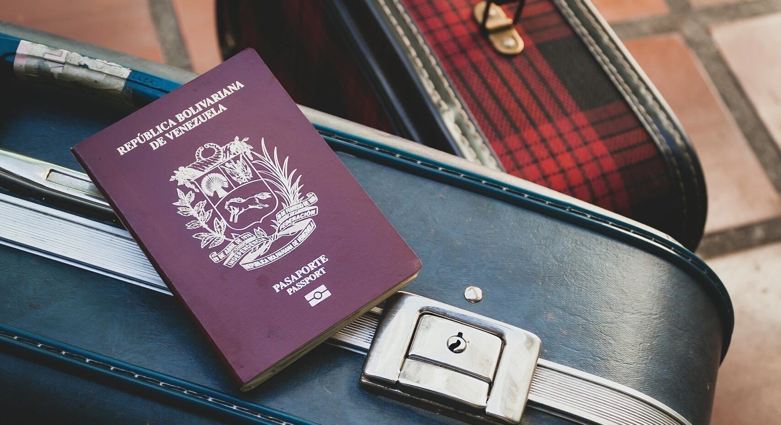 Venezuelan passport resting on vintage suitcases, ideal travel concept imagery for vacation and adventure themes.